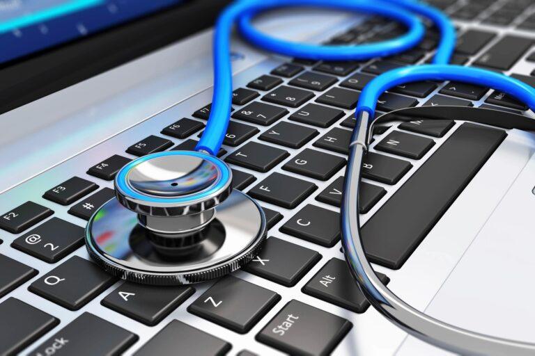 A blue stethoscope sitting on a keyboard.