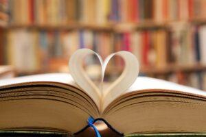 An open book with a page folded into the shape of a heart.