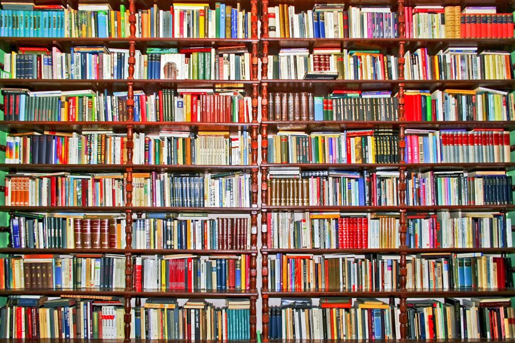A floor to ceiling bookshelf stuffed with books of all colors.